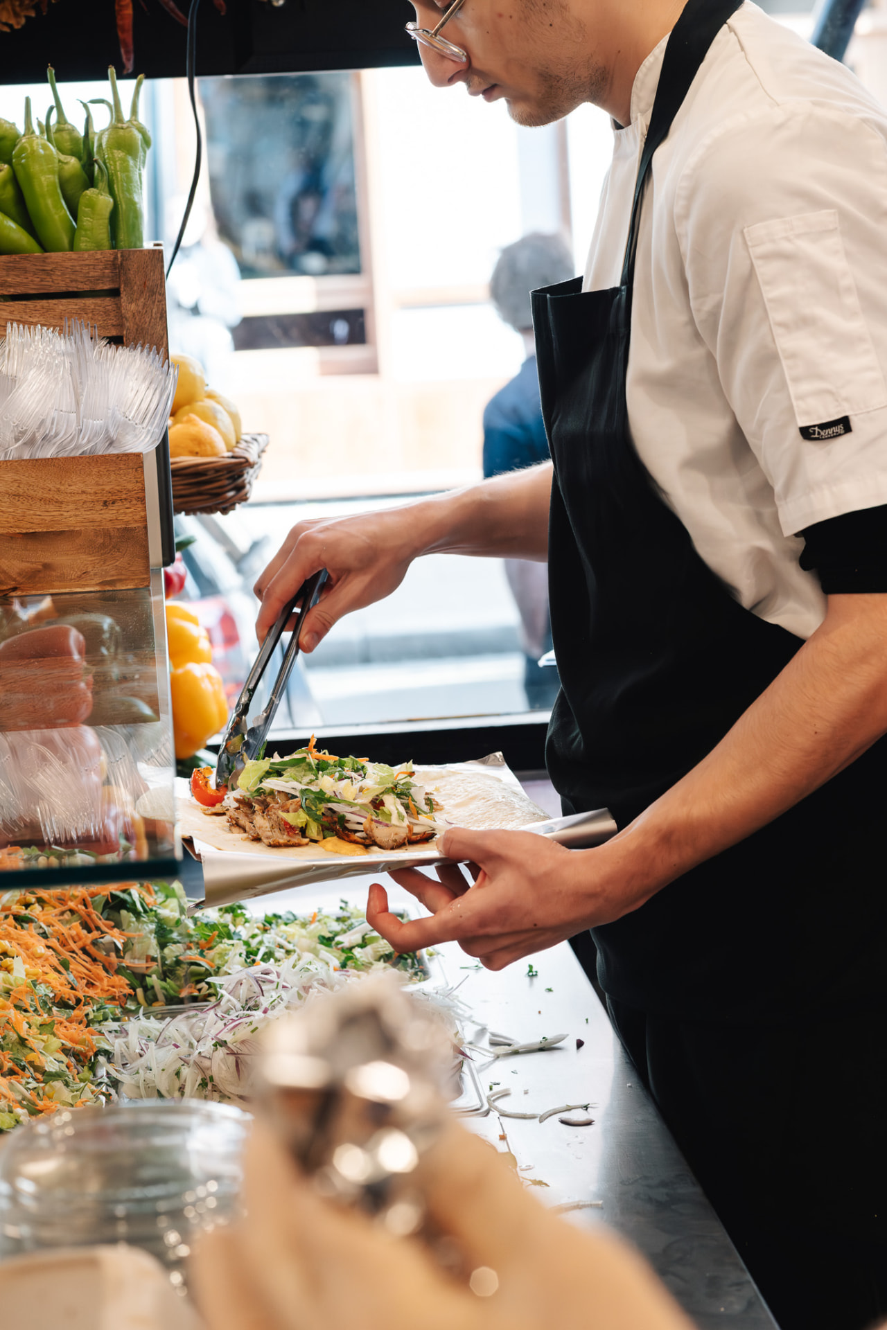 A Checkpoint chef assembling a fresh döner wrap at the counter